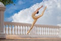 Slender ballerina in pointe shoes and bridal costume is jumping against the background of sea Royalty Free Stock Photo