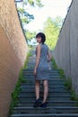 A slender brunette climbs the stairs in a narrow Royalty Free Stock Photo