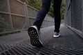 Slender female legs in blue jeans and grey sneakers walking along forest trail Royalty Free Stock Photo