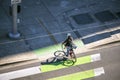 Woman in a helmet rides a bicycle crosses the road at a crossroads at a pedestrian crossing with a dedicated bike path Royalty Free Stock Photo