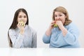 Slender girl eats healthy food, Fat woman eats harmful fast food. On a white background, the theme of diet and proper Royalty Free Stock Photo