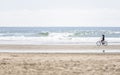 Slender girl rides a bicycle breathing fresh sea air riding along the Pacific Ocean