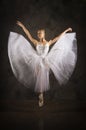 Slender girl in a white corset tutu dancing ballet