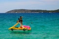 Slender girls in bathing suits float on an inflatable boat on the beautiful sea in Sibenik, Croatia, Croatian beach, rest