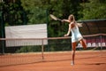 Slender lady is playing tennis on court Royalty Free Stock Photo