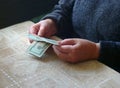 Slender purse. Old woman holding dollar cash money in hands at home Royalty Free Stock Photo