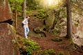 Slender serious female going down hill, being inspired by nature, wandering around stony slopes, forest trees, having vacation,