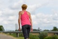 Slender sporty woman walking along a footpath Royalty Free Stock Photo