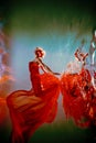 girl with an athletic figure and blond hair, with red material and light underwear, in a ballet pose underwater Royalty Free Stock Photo