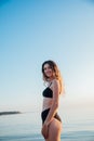 Beautiful slender woman in black swimsuit sunbathing on the beach Royalty Free Stock Photo