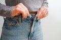 A slender woman fastens a button of her blue jeans. Weight ungain woman getting dressed wearing jeans. Close up of girl buttoning Royalty Free Stock Photo