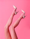 Slender woman wearing sexy pink fishnet stockings and stilettos Royalty Free Stock Photo