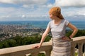 A slender young beautiful girl with a scarf on her head looks from a height at the city of Batumi