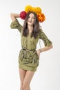 Slender young cheerful girl brown hair dances with a bouquet of colorful flowers on her head Royalty Free Stock Photo