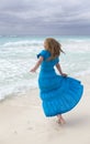 Slender young woman with long hair fluttering in the wind in a blue dress on the shore of a stormy sea on a sandy beach Cuba, Var Royalty Free Stock Photo
