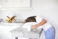 Sleppy woman with cup of coffee and pillow on the kitchen in morning