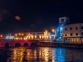 Slgo, Ireland: 12.05.2021: Beautiful decorated and illuminated buildings on river side and reflection in water. Town night scene. Royalty Free Stock Photo