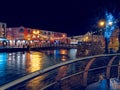 Slgo, Ireland: 12.05.2021: Beautiful decorated and illuminated buildings on river side and reflection in water. Town night scene. Royalty Free Stock Photo