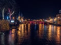 Slgo, Ireland: 12.05.2021: Beautiful decorated and illuminated buildings on river side and reflection in water. Town night scene. Royalty Free Stock Photo