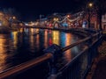 Slgo, Ireland: 12.05.2021: Beautiful decorated and illuminated buildings on river side and reflection in water. Town night scene. Royalty Free Stock Photo