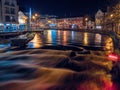 Slgo, Ireland: 12.05.2021: Beautiful decorated and illuminated buildings on river side and reflection in water. Town night scene. Royalty Free Stock Photo