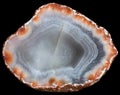 Slice of agate geode with red zeolites on the periphery