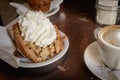 A slice of apple pie with whipped cream and a cappuccino coffee on a wooden table. Royalty Free Stock Photo