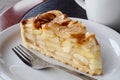 A slice of apple pie on white ceramic plate with fork. Black and Royalty Free Stock Photo