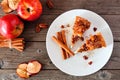 Slice of autumn caramel apple pecan cheesecake, top view table scene over wood