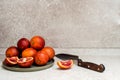 Slice of blood orange on the kitchen table. Sicilian blood oranges and knife Royalty Free Stock Photo