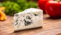 Slice of blue cheese on a cutting board with vegetables in the background Royalty Free Stock Photo