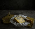 Slice of blue cheese cheese on wooden board with cheese knife. Low key still life Royalty Free Stock Photo