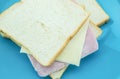 Slice of bread with cheese and ham on blue plate with white back Royalty Free Stock Photo
