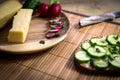 Bread with cucumber and a wooden plate with cheese