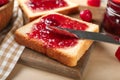 Slice of bread with delicious strawberry jam on board, closeup Royalty Free Stock Photo