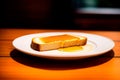 Slice of bread with honey on a white plate on wooden table