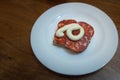 Slice of bread with kulen sausage and mayonnaise on a plate