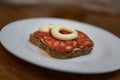 Slice of bread with kulen sausage and mayonnaise on a plate