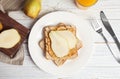 Slice of bread with peanut butter and pear on white wooden table Royalty Free Stock Photo