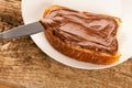 Slice of bread with sweet chocolate nougat spread on white plate Royalty Free Stock Photo