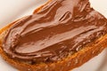 Slice of bread with sweet chocolate nougat spread on white plate Royalty Free Stock Photo
