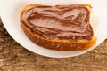 Slice of bread with sweet chocolate nougat spread on white plate Royalty Free Stock Photo