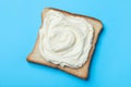 Slice of bread with tasty cream cheese on light blue background, top view Royalty Free Stock Photo