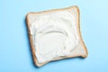 Slice of bread with tasty cream cheese on light blue background, top view Royalty Free Stock Photo