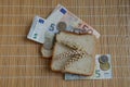 Slice of bread and wheat ears on Euro banknotes Royalty Free Stock Photo