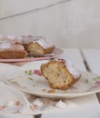 Slice of cake Ciambellone with crumbs on ceramic plate painted with floral motifs, cloth towel and mother of pearl fragments. Royalty Free Stock Photo