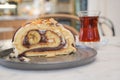 A slice of cake on serveware next to a glass of tea drinkware