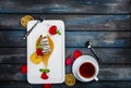 Slice of Cheesecake with a cup of tea on a white plate with rose petals. Top view. Beautiful wooden background. Royalty Free Stock Photo