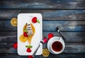 Slice of Cheesecake with a cup of tea on a white plate with rose petals. Top view. Beautiful wooden background. Royalty Free Stock Photo