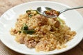 Slice chili fish sauce in spoon dressing fried rice with pork and Chinese kale on plate